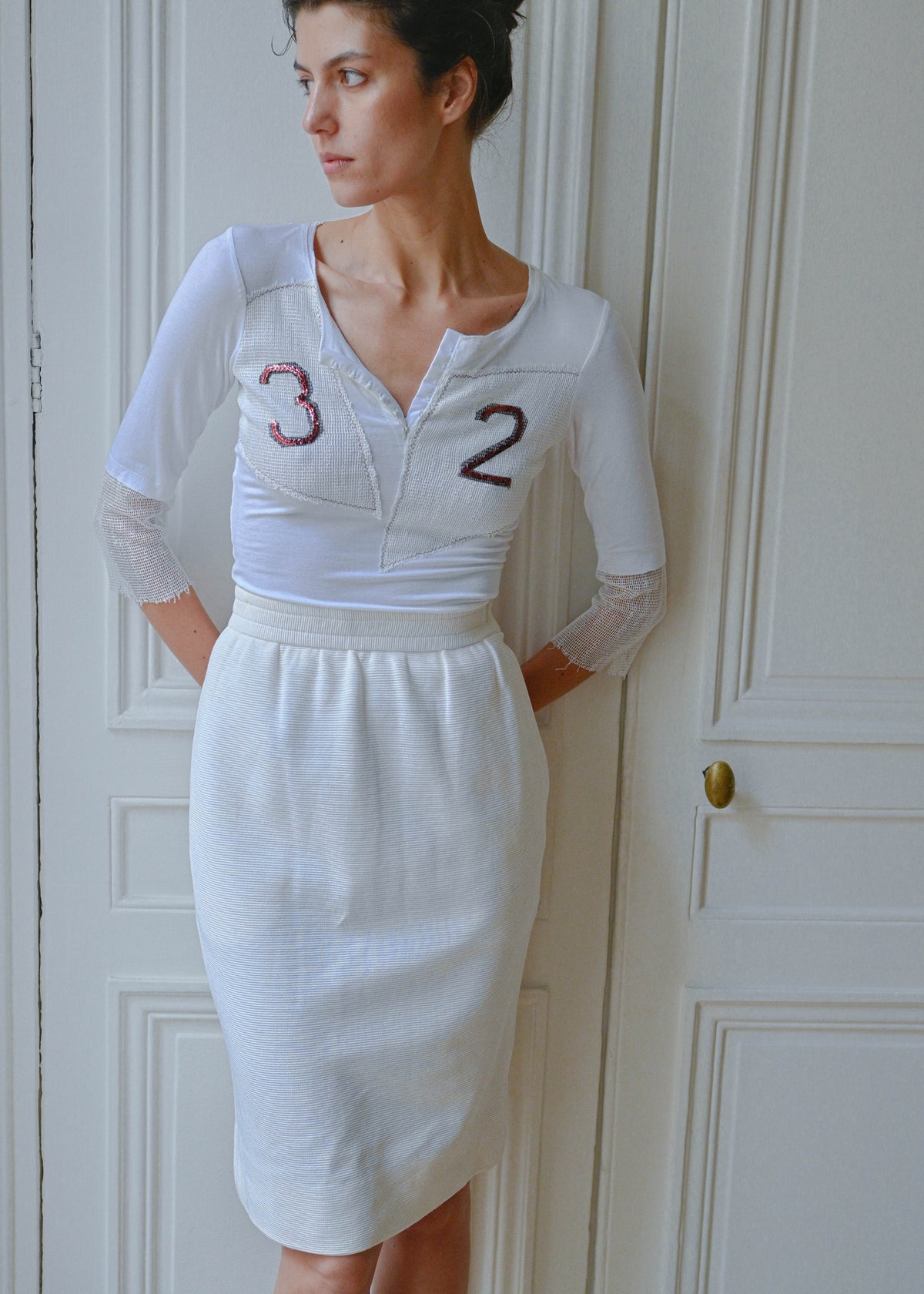 Vintage white sequin number 32 jersey top, front view, worn with a white Givenchy pencil skirt, TURN Paris