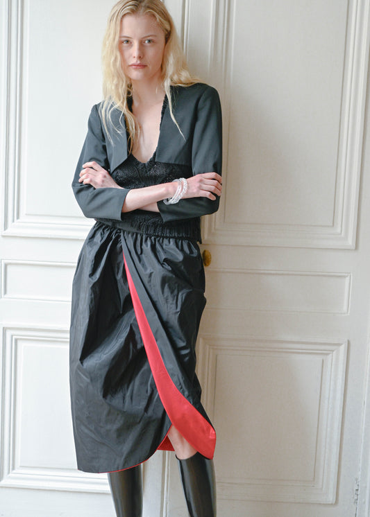 Vintage long black skirt with an open front and a red lining, side view, TURN Paris