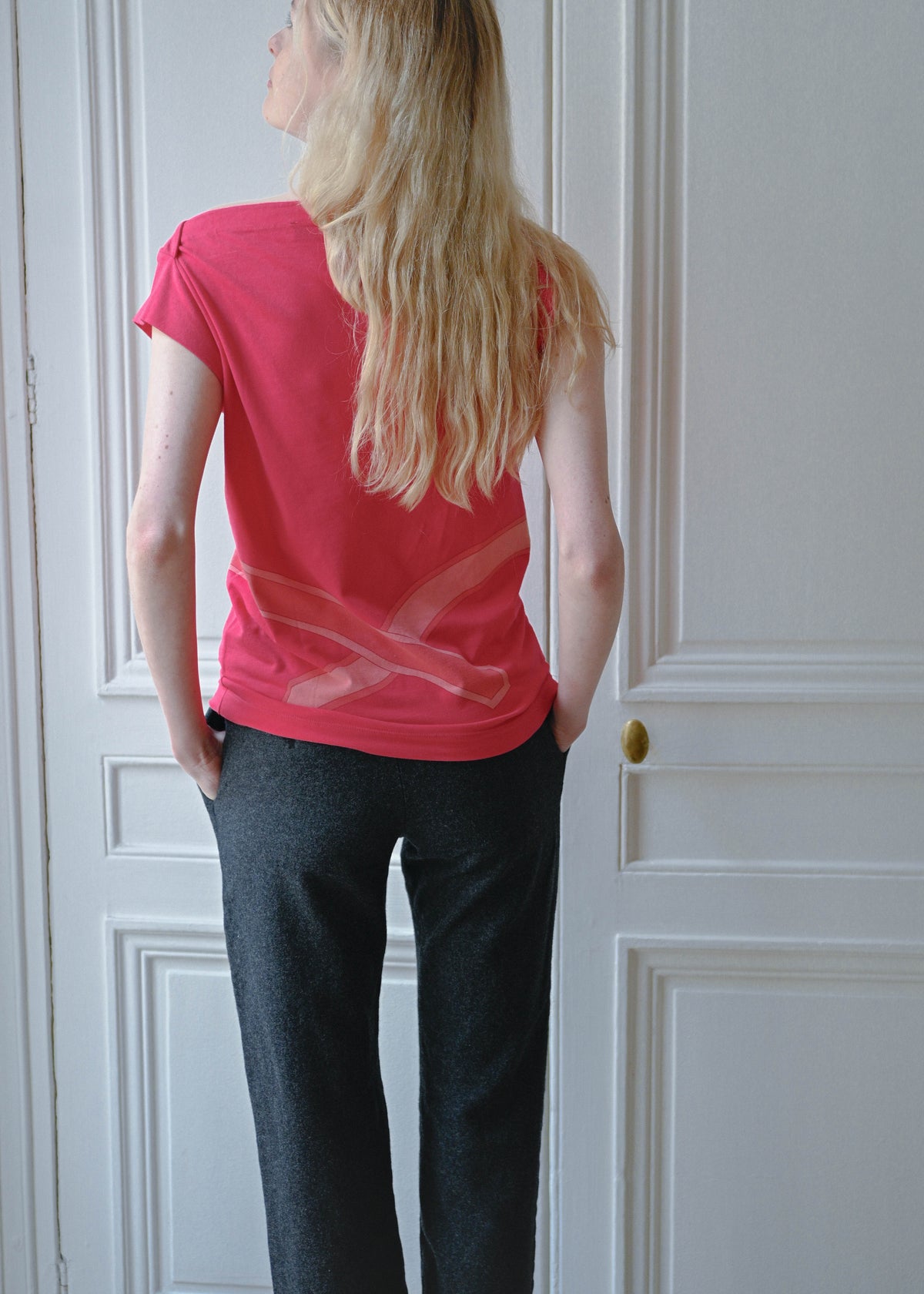 Vintage red sleeveless top with a trompe l'oeil belt print, worn with grey wool trousers, back view, TURN Paris