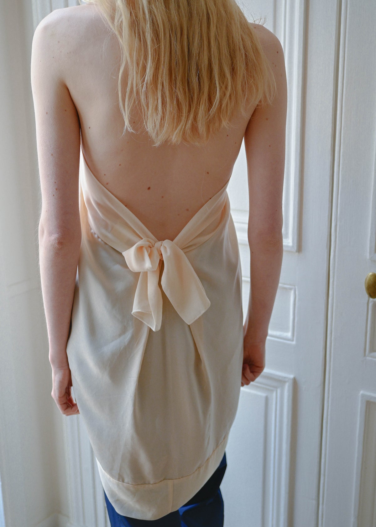 Vintage beige draped halter top with an open back and a bow, worn with the TURN Comeback Capri in blue, back view, TURN Paris