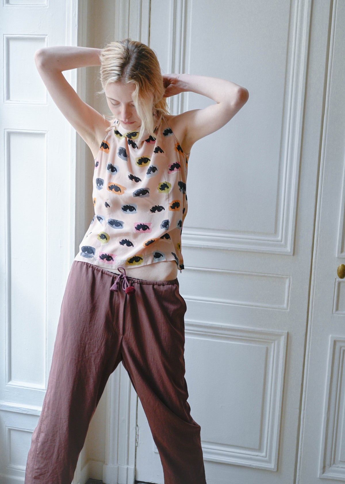 Vintage Moschino sleeveless top with an eyes print, worn with the TURN Loose Pant in burgundy, side view, TURN Paris