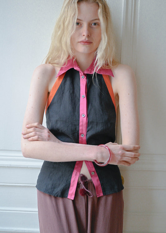 Vintage black silk sleeveless top with a pink collar, orange piping and an open back, front view, TURN Paris