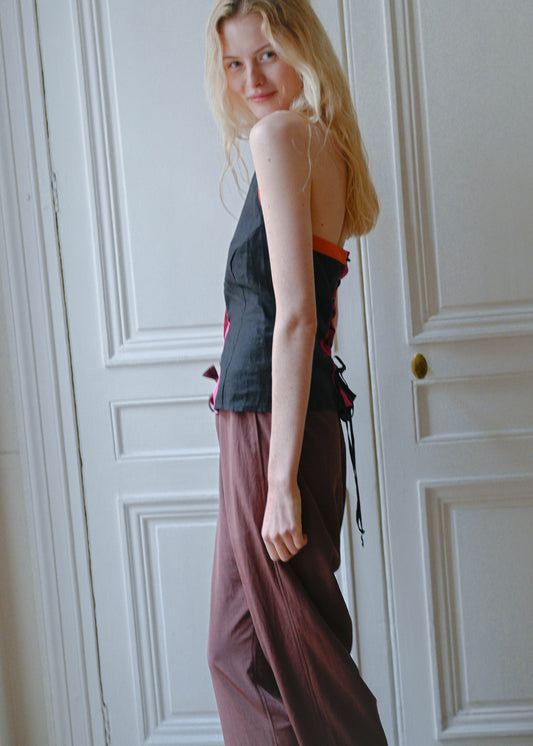 Vintage black silk sleeveless top with a pink collar, orange piping and an open back, side view, TURN Paris