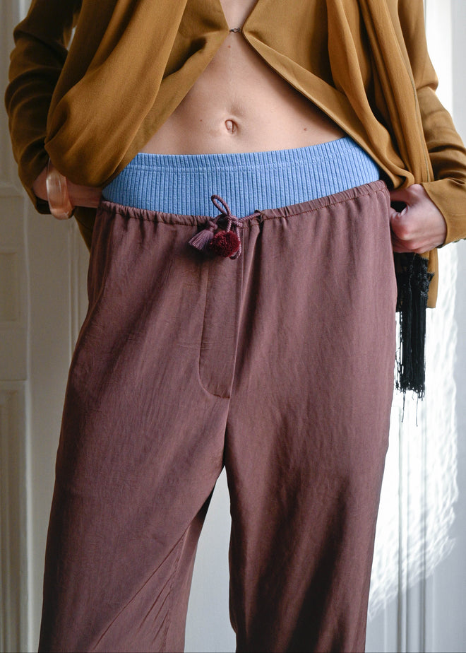 TURN PARIS flowing trousers with a loose, straight cut.

Tied at the waist with a custom-made asymmetrical pompon, made in France.

Designed to create space around the leg, balancing more structured silhouettes and naturally draping over both flat shoes and heels.