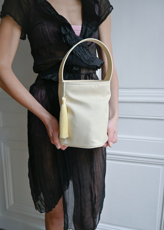 TURN BUCKET BAG 

A functional and structured bucket bag designed to hold daily essentials while maintaining its shape.

Completed with an interior pocket for organisation and a tassel puller detail.

20 cm height / 19 cm depth / 48 cm circumference.