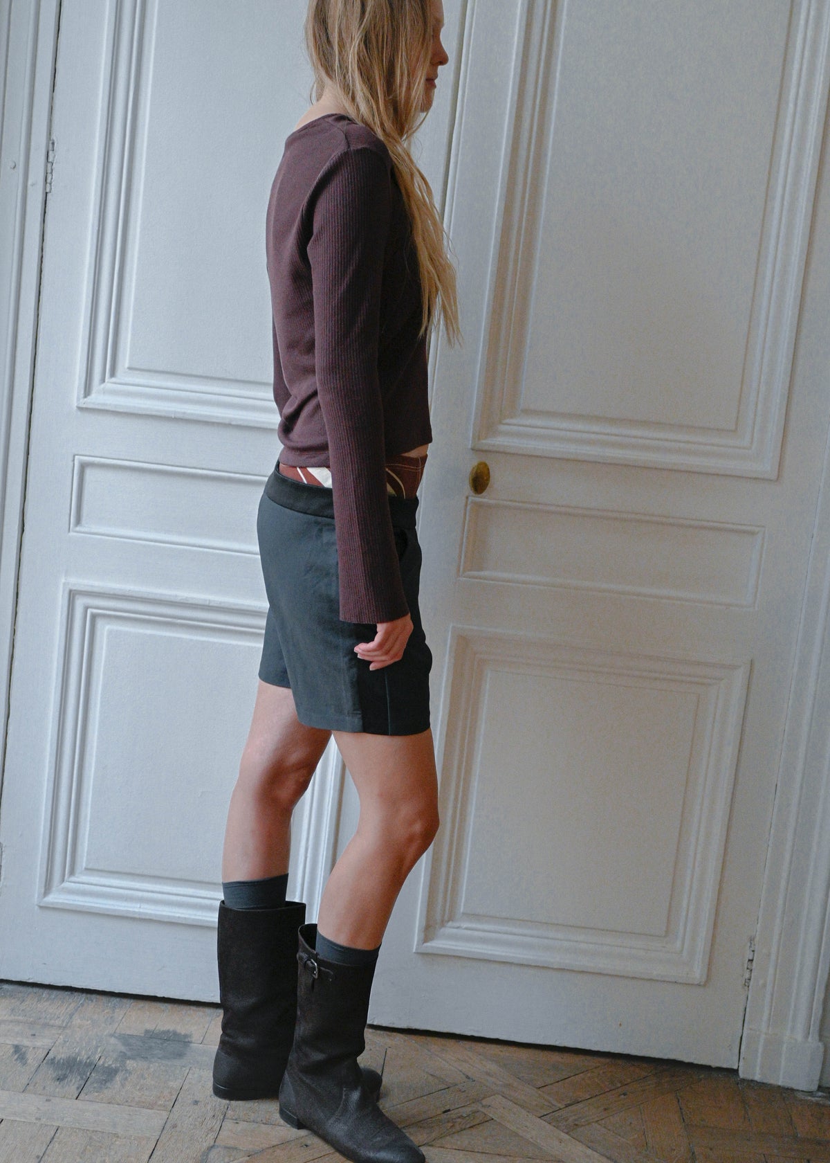 Black silk shorts worn with a plum knit top, side view