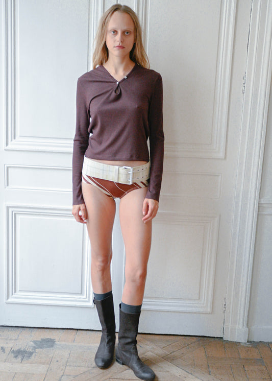 Striped briefs worn with a plum knit top, front view