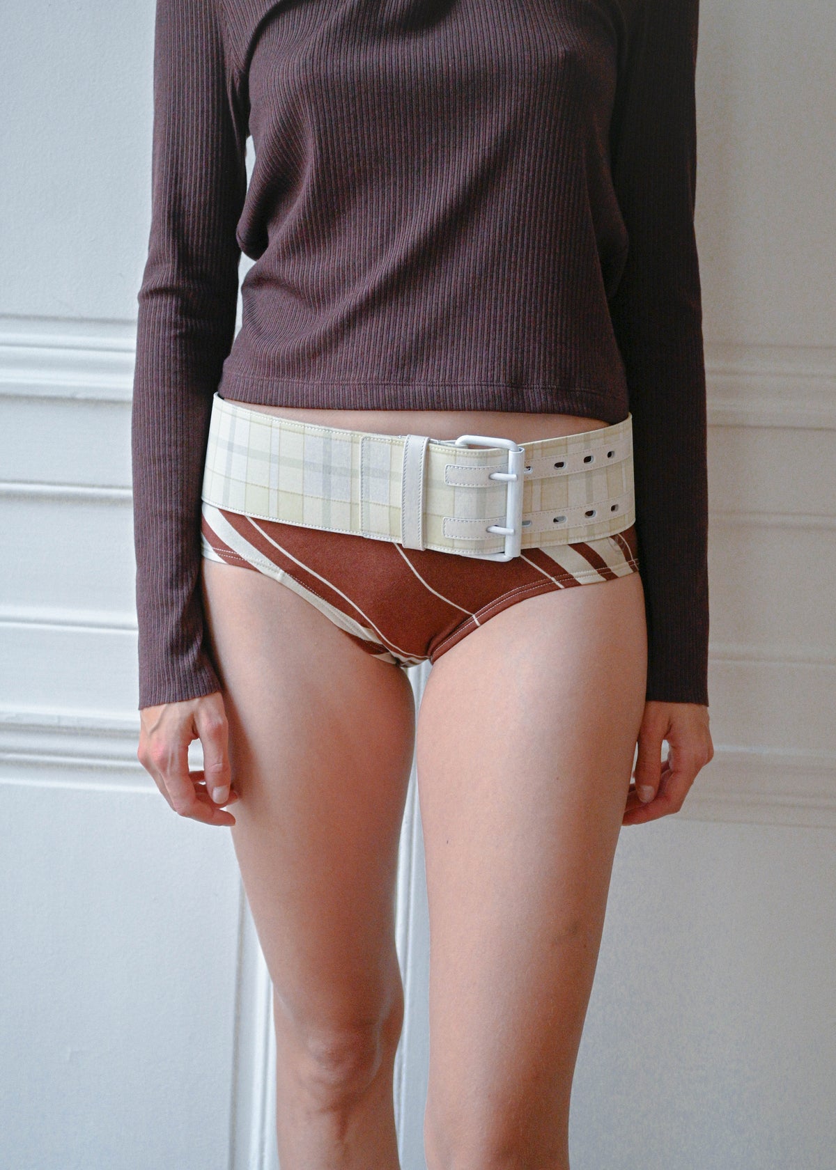 Striped briefs worn with a plum knit top and cream belt, close-up