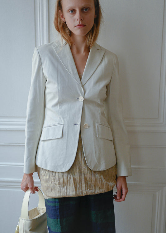 Cream leather jacket worn with gold textured mini dress and striped linen skirt, front view