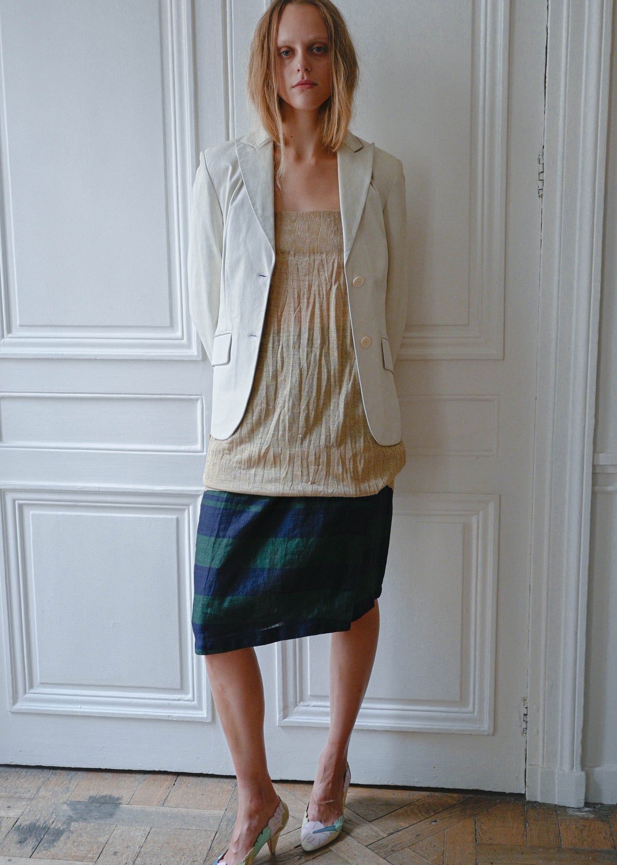 Cream leather jacket worn open over gold textured mini dress, front view