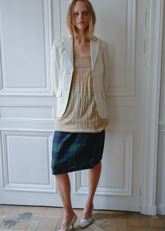 Cream leather jacket worn open over gold textured mini dress, front view