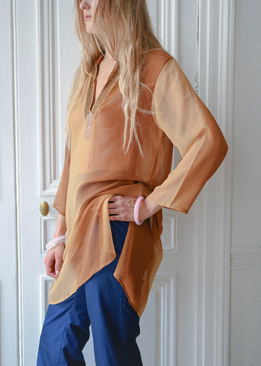Bronze chain neck tunic worn with navy cropped trousers, front view
