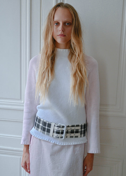 Pink and white knit sweater with checks belt, close-up