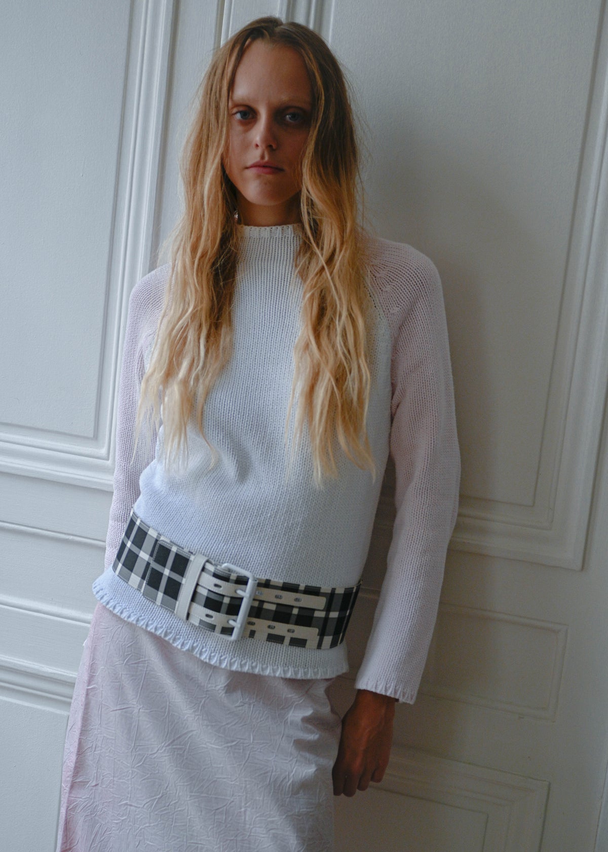 Pink and white knit sweater worn with crinkled print midi skirt and checks belt, front view