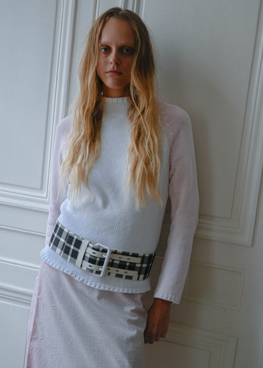 Pink and white knit sweater worn with crinkled print midi skirt and checks belt, front view