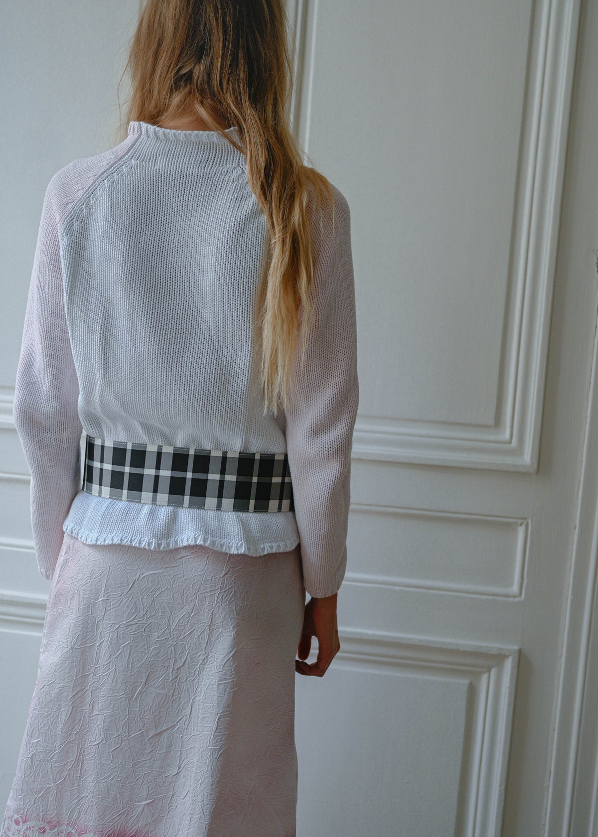 Pink and white knit sweater worn with crinkled print midi skirt, back view