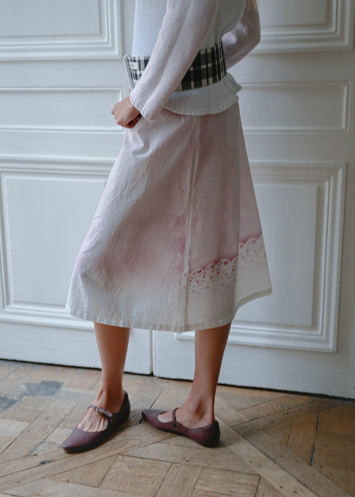Crinkled print midi skirt worn with pink and white knit sweater, side view