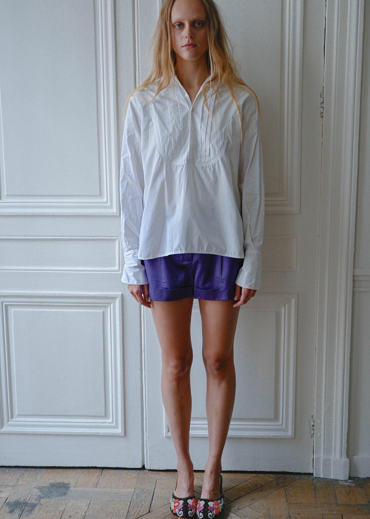 White cotton shirt worn with purple shorts, front view