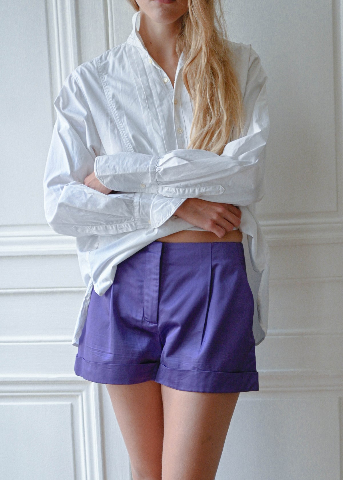 Purple shorts worn with white cotton shirt, front view