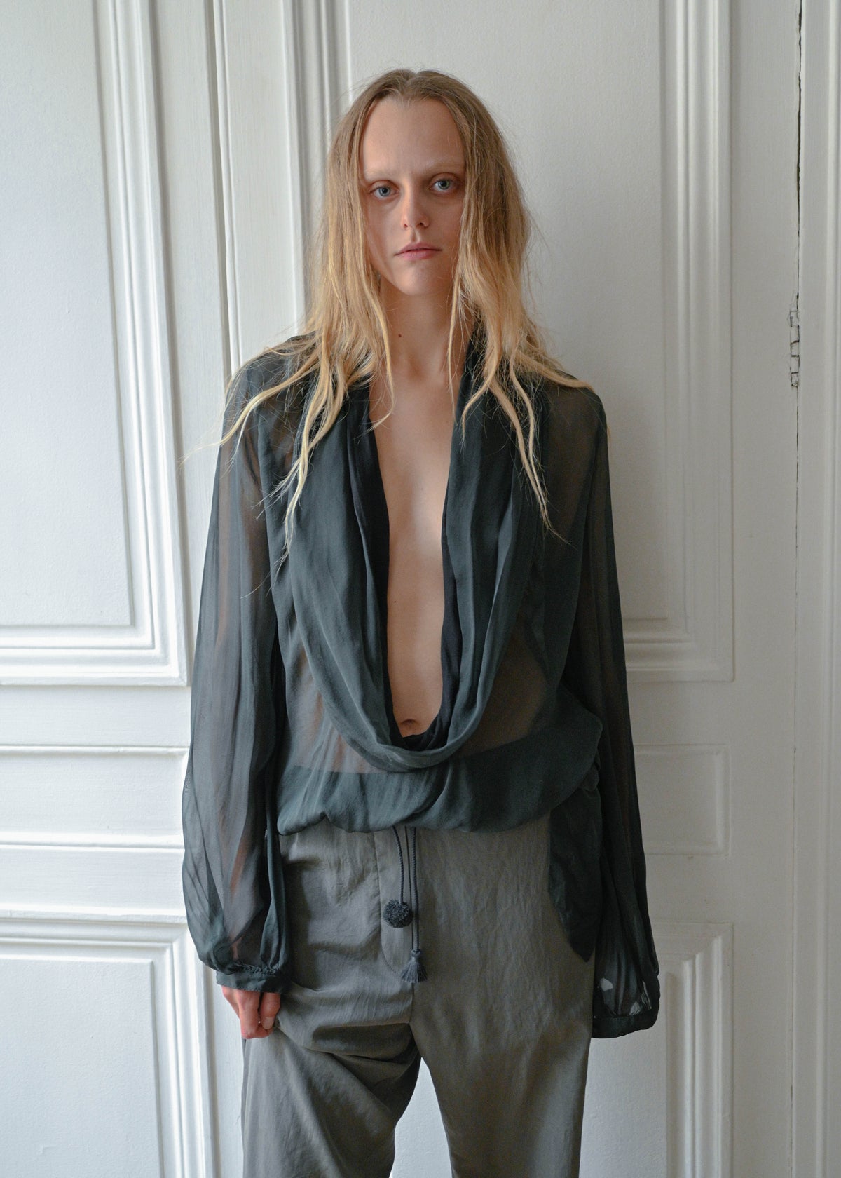 Green sheer draped blouse with a deep draped neckline, close-up