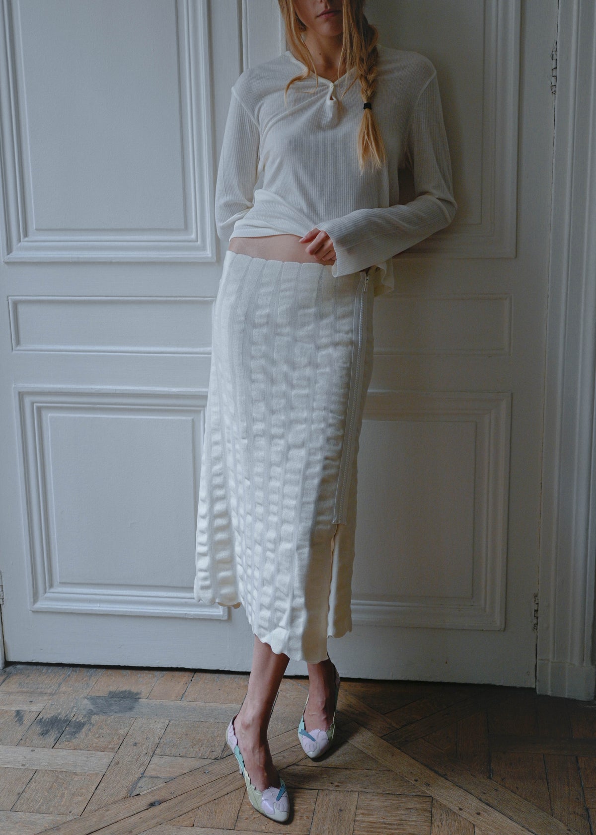 Cream knit maxi skirt worn with a white long sleeve top, side view