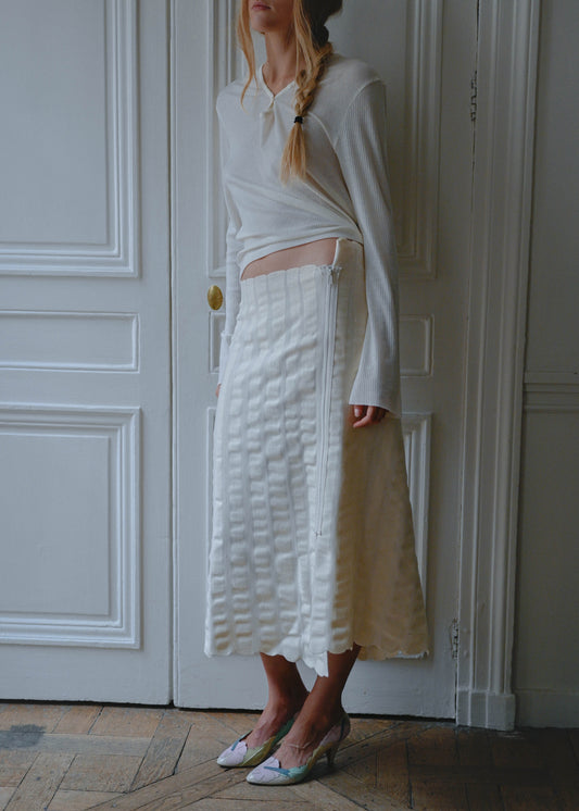 Cream knit maxi skirt worn with a white long sleeve top, front view