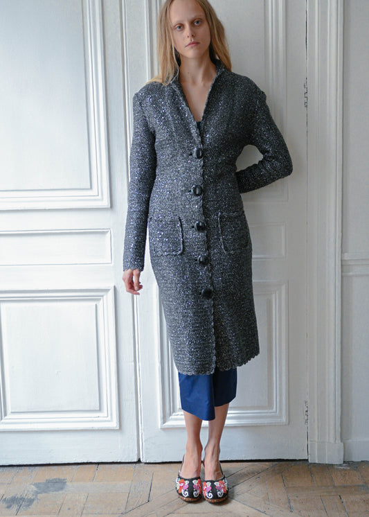 Grey and silver maxi cardigan coat worn with navy cropped trousers, front view