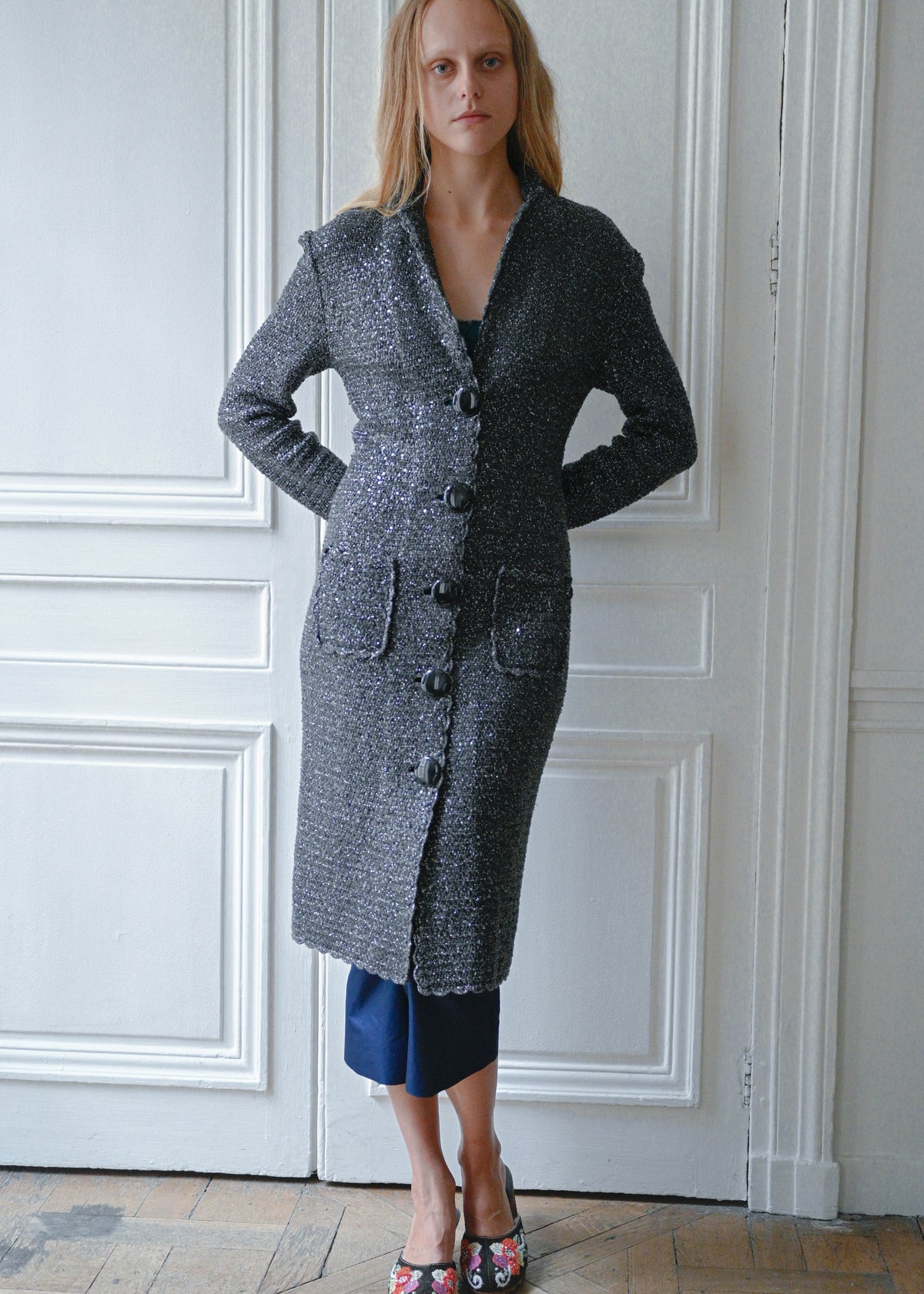 Grey and silver maxi cardigan coat worn with navy cropped trousers, front view