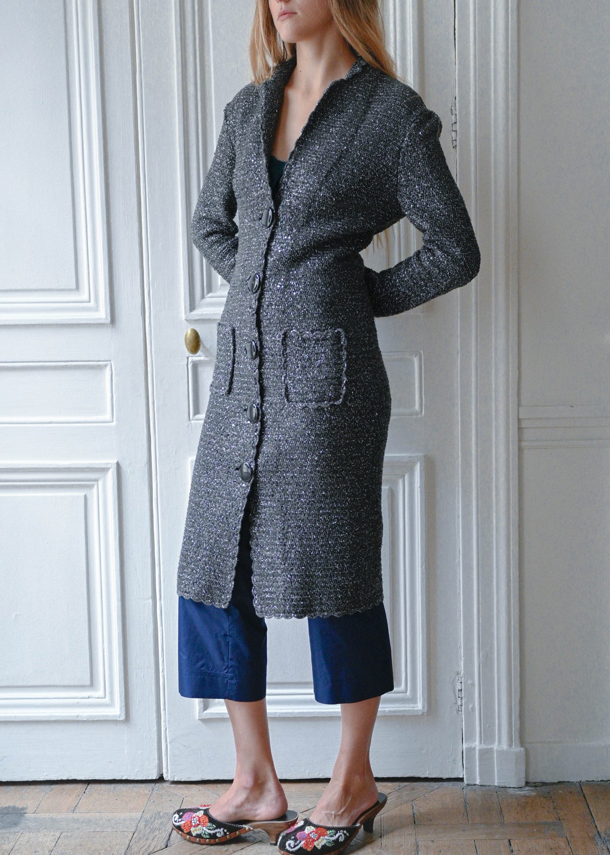 Grey and silver maxi cardigan coat worn with navy cropped trousers, front view