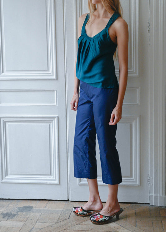 Turquoise silk cami worn with navy cropped trousers, front view