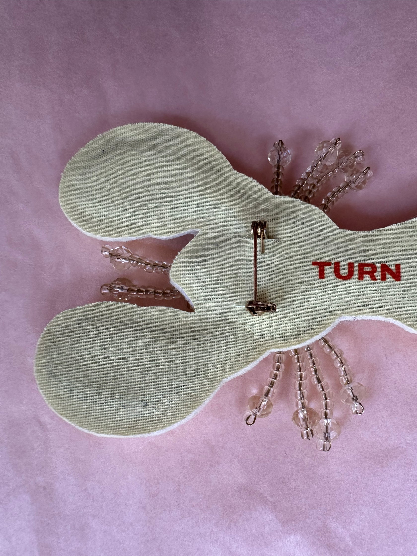 TURN PARIS lobster brooch in cream, embroidered with beads and gemstone embellishments across the body and claws.

Designed with a flat base and metal pin at the back, to be worn on a bag, jacket or shoe.

10 cm length.