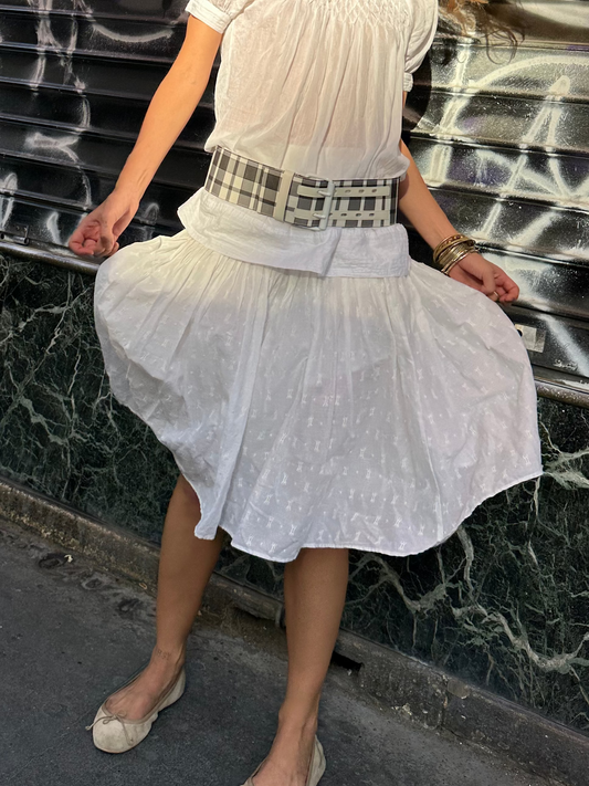 TURN Paris thick belt in black on cream check woven fabric applied to a leather base, finished with a hand-painted white buckle. The belt holes are reinforced with leather.