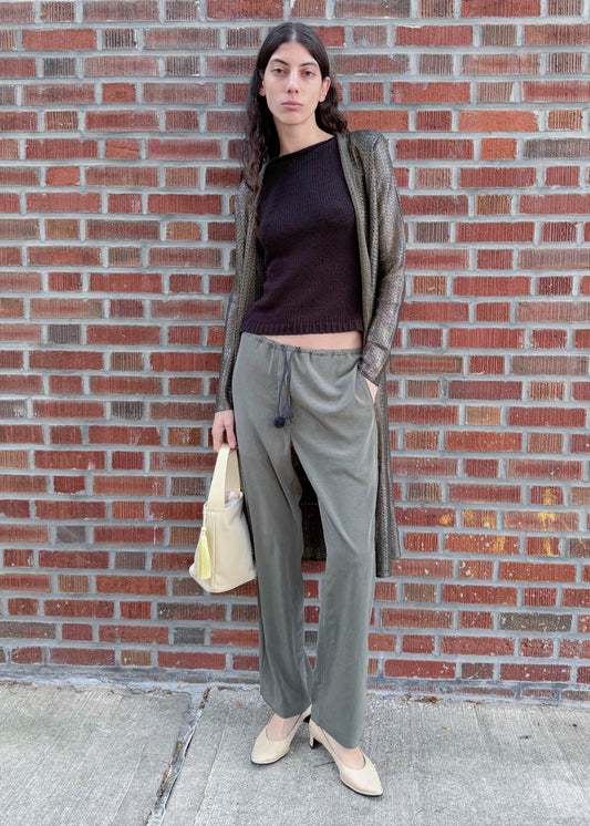 TURN Paris flowy loose pant in green, tied at the waist with a custom-made asymmetrical pompon made in France.