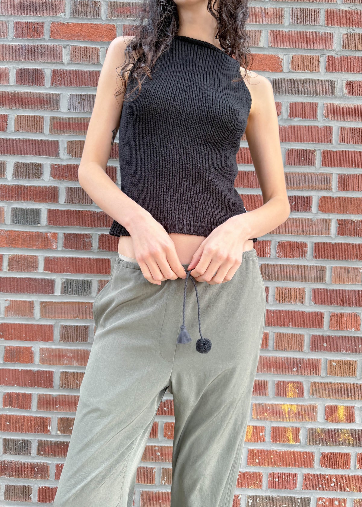 TURN Paris flowy loose pant in green, tied at the waist with a custom-made asymmetrical pompon made in France.
