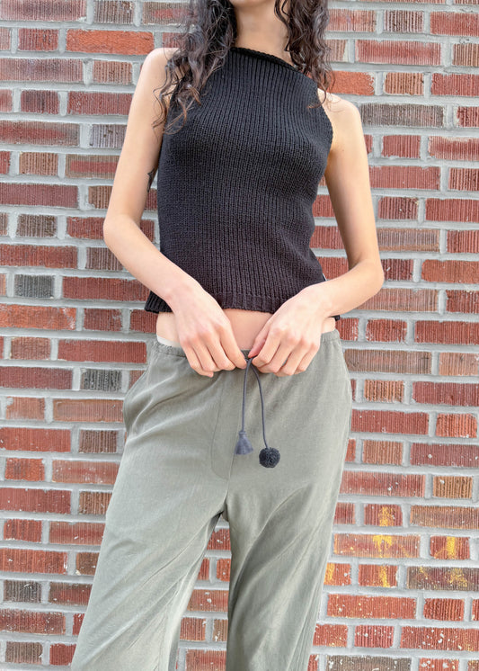 TURN Paris flowy loose pant in green, tied at the waist with a custom-made asymmetrical pompon made in France.