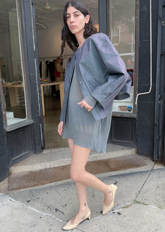 TURN Paris bomber jacket in glazed Japanese denim, cut in a boxy silhouette with rounded sleeves and slanted pockets, designed to enhance posture and subtly reveal the lower back.
