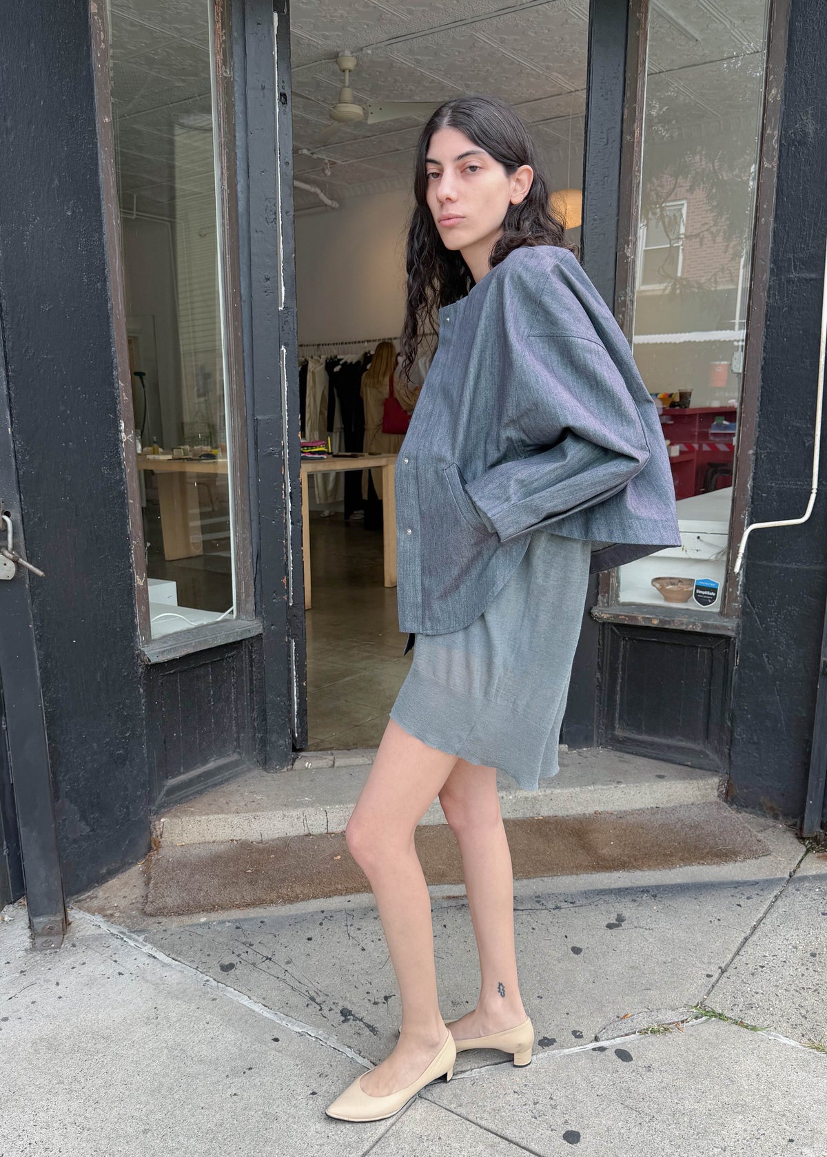 TURN Paris bomber jacket in glazed Japanese denim, cut in a boxy silhouette with rounded sleeves and slanted pockets, designed to enhance posture and subtly reveal the lower back.