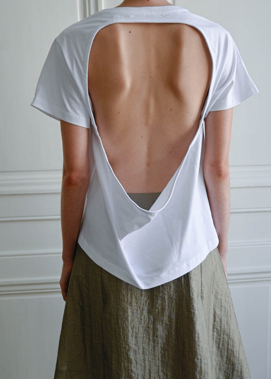 TURN PARIS TEE IN COTTON, CUT IN A SIMPLE SILHOUETTE, WITH AN O-SHAPED CUTOUT AT THE BACK THAT FOLLOWS THE NECKLINE AND DRAPES AT THE BOTTOM. A NOD TO THE HUNGARIAN Ö.&nbsp;

DESIGNED TO REVEAL THE BACK WITH A GEOMETRIC OPENING, BRINGING AN UNEXPECTED TWIST TO AN EVERYDAY STAPLE.