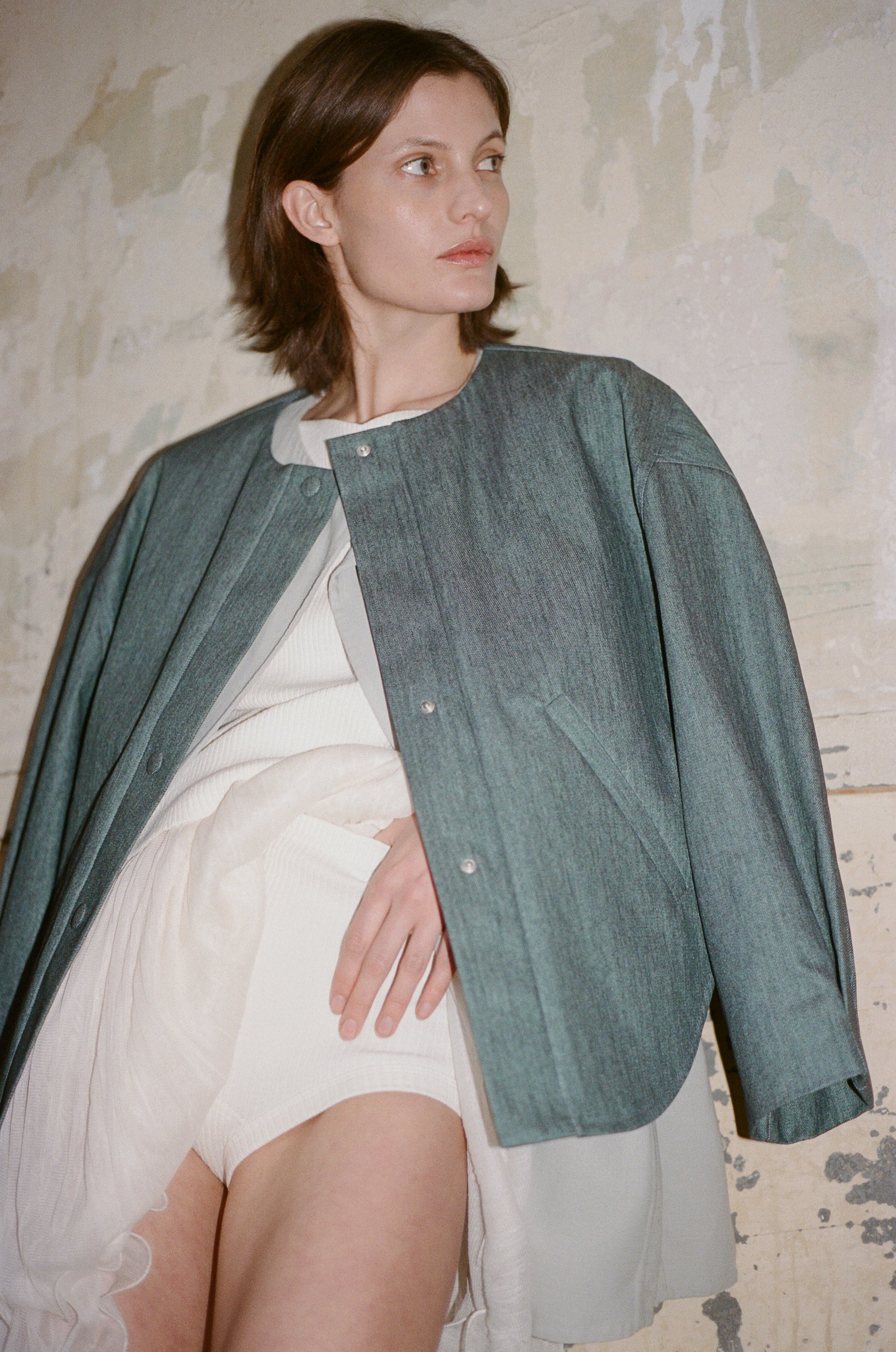 TURN PARIS bomber jacket in glazed Japanese denim, cut in a boxy silhouette with rounded sleeves and slanted pockets.

Designed to enhance posture and create a rounded, open shape at the back, subtly revealing the lower back.