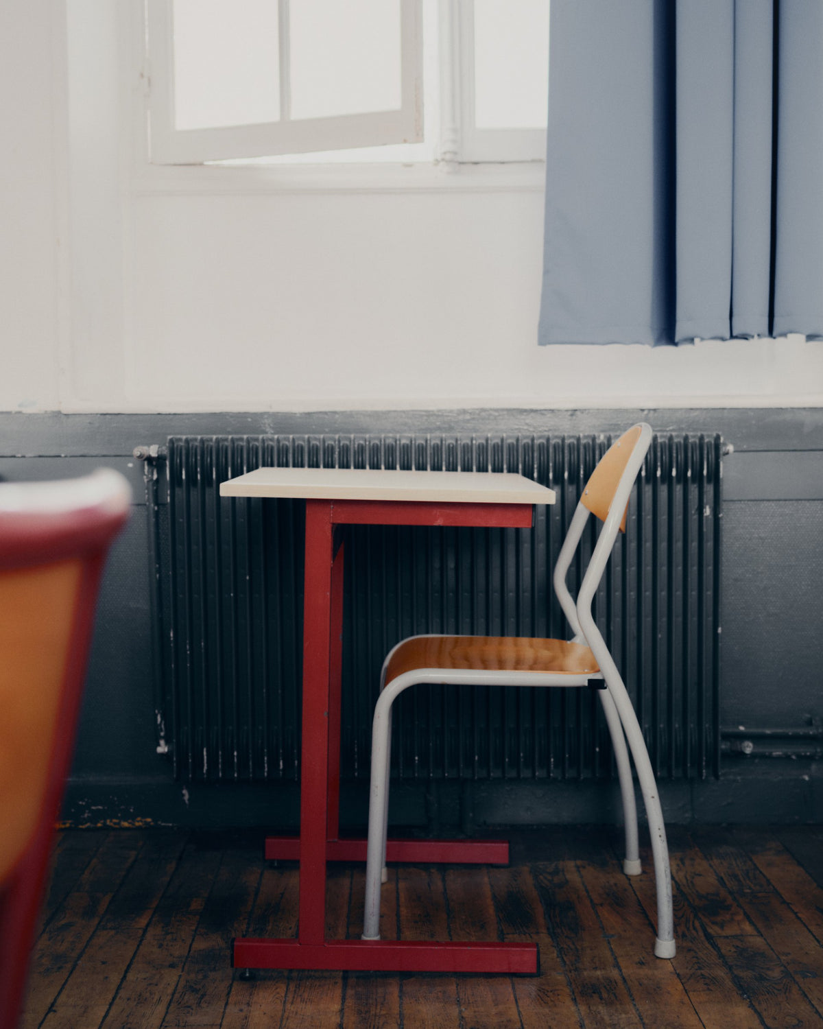 Empty school desk and chair by a radiator, still life from the TURN Paris FW26 Paire collection