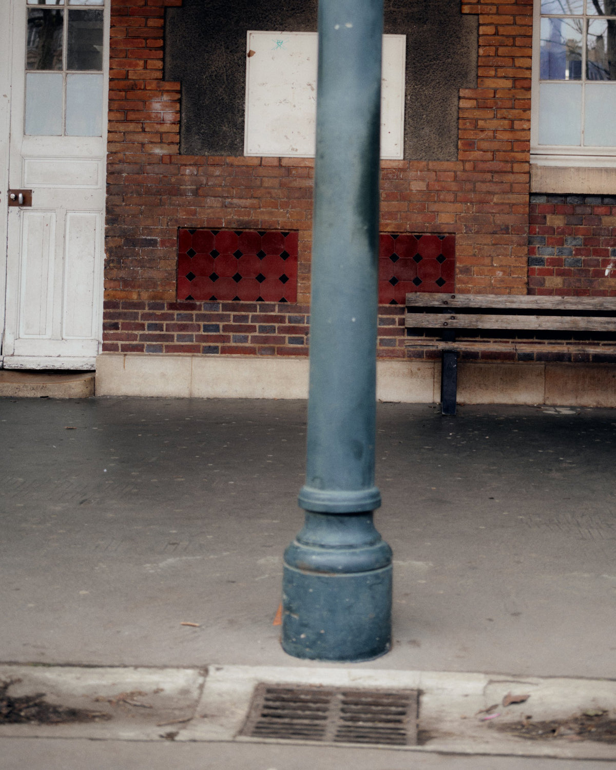 Street lamppost in front of a brick school building, TURN Paris FW26 Paire collection